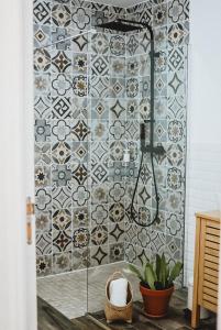 a bathroom with a shower with a tiled wall at Villa Couleur Nature in Salazie