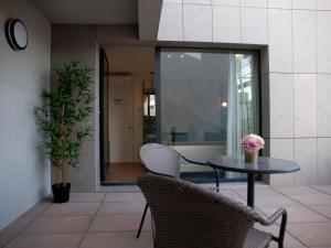 eine Terrasse mit einem Tisch, Stühlen und einem Fenster in der Unterkunft New Style Lisbon Hotel in Lissabon