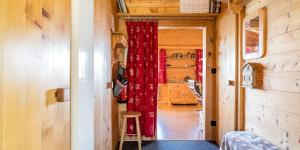 um corredor com uma cortina vermelha numa pequena casa em Burehüsli Axalp em Axalp