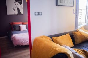 een woonkamer met een bank en een bed bij T2 Cosy & moderne avec Parking Privé Gratuit à Villeurbanne in Villeurbanne