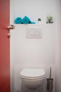 een badkamer met een wit toilet en blauwe handdoeken bij T2 Cosy & moderne avec Parking Privé Gratuit à Villeurbanne in Villeurbanne