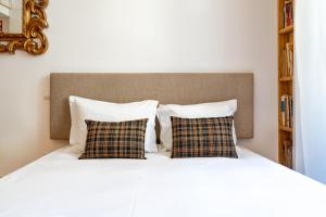 a bed with two pillows and a headboard at VIVA Library Studio in Porto +2 photos