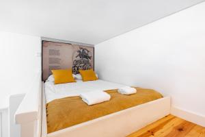 a bedroom with a bed with two pillows on it at VIVA Library Studio in Porto