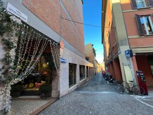 an empty street with a building and a store at HouSmart Senzanome 9/3 in Bologna