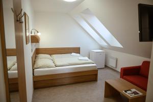um quarto com uma cama e uma cadeira vermelha em Penzion Sudomír em Sudoměřice