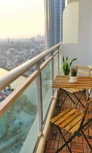 een balkon met een houten tafel en stoel in een gebouw bij A2J 1BR Luxury River View Suite Near Rockwell Mall in Manilla
