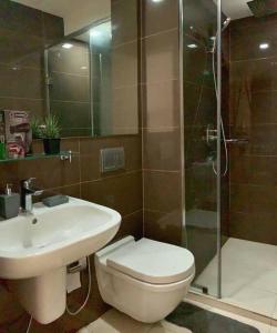 een badkamer met een toilet, een wastafel en een douche bij A2J 1BR Luxury River View Suite Near Rockwell Mall in Manilla