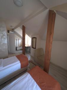 una camera con due letti e una sedia in una stanza di Hotel Orient a Blagoevgrad