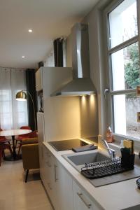 a kitchen with a sink and a stove top oven at Le gite des 3 mousquetaires in Amboise