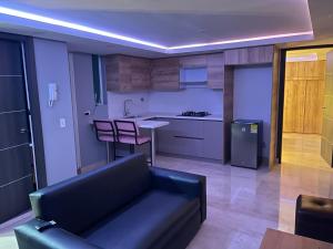 ein Wohnzimmer mit einem Sofa und einer Küche in der Unterkunft Soho Deluxe in Medellín