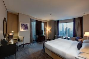 a hotel room with a large bed and a television at Rose Rayhaan by Rotana - Dubai in Dubai