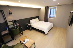 une chambre d'hôtel avec un lit et une table dans l'établissement Wolgot Unique Hotel 28, à Siheung