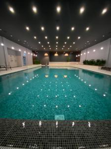 - une piscine d'eau bleue dans un bâtiment dans l'établissement Crama Jelna Resort & Spa, à Orheiu Bistriţei