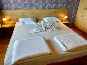 ein weißes Bett mit einer Schleife und zwei Lampen in der Unterkunft Dragoman Hotel in Dragoman