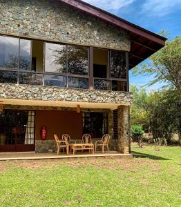 a house with chairs and a table in front of it at Oilepo Cottage in Naivasha