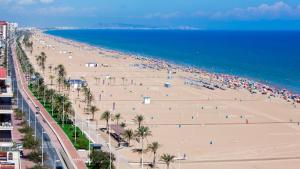 widok na plażę z palmami i oceanem w obiekcie A 1 MINUTO DE LA PLAYA Alojamiento 2 habitaciones - Aire Acc y ascensor w mieście Playa de Gandia