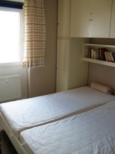 Schlafzimmer mit einem großen weißen Bett und einem Fenster in der Unterkunft Vier Jahreszeiten I 50 in Großenbrode