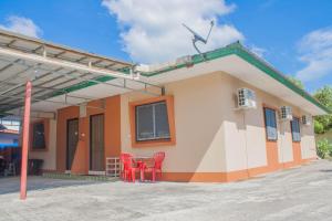 two red chairs in front of a building at Bunut Centre Stay in Bandar Seri Begawan