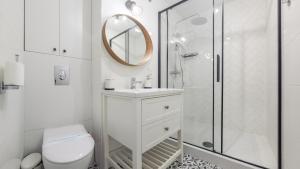 a white bathroom with a shower and a toilet at Apartamenty Sun & Snow Ustka Centrum in Ustka