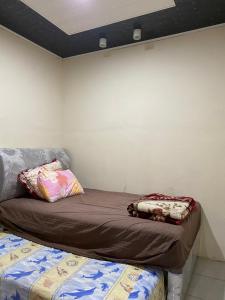 a bed sitting in a room next to a wall at Paima Homestay in Balige