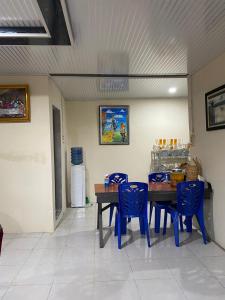a dining room with blue chairs and a table at Paima Homestay in Balige
