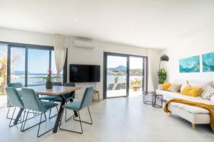 ein Wohnzimmer mit Tisch und Couch in der Unterkunft Seashore House " Es tamarells" in Alcúdia