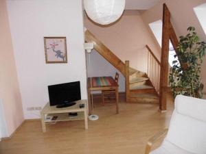 a living room with a tv and a staircase at Sehr-schoene-4-Raum-Maisonette-Fewo-mit-110qm-Balkon-zentral-preiswert-T7 in Dresden