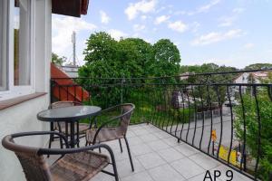 a balcony with a table and chairs and a view of a city at Apartament Rybacka 84/9 in Krynica Morska - Piaski