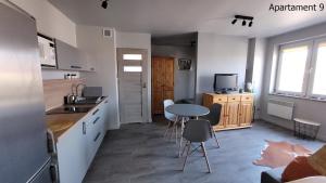 a kitchen with a table and chairs in a room at Apartament Rybacka 84/9 in Krynica Morska - Piaski