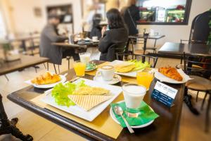 una mesa con platos de comida y bebidas. en Le Camere Dei Conti - Guest House, en Florencia