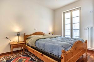 - une chambre avec un lit en bois et une fenêtre dans l'établissement Appartamento al nido Grauno OSPITAR, à Grauno