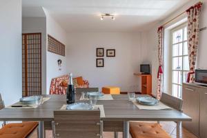 - une cuisine et une salle à manger avec une table et des chaises dans l'établissement Appartamento al nido Grauno OSPITAR, à Grauno