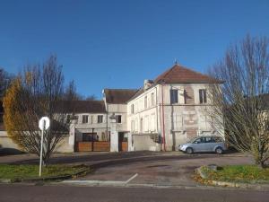 una casa vieja con un coche aparcado delante de ella en Apt neuf / tout confort / 7 mn d'Auxerre / Netflix 