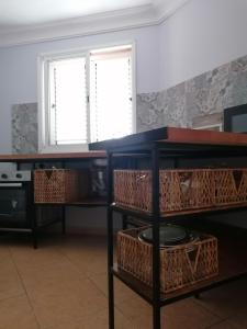 a kitchen with a table with baskets on it at Amber House in Arinaga