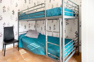 a bedroom with two bunk beds and a chair at Playa Sardina in Gáldar +17 photos