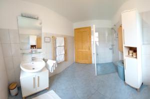 a white bathroom with a sink and a shower at Weslhof in Attersee am Attersee