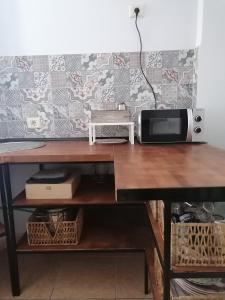 einen Schreibtisch mit einer Mikrowelle und einem Computer darauf in der Unterkunft Amber House in Arinaga
