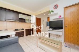 a kitchen with a red living room with a tv at RedLiving Apartemen Mediterania Palace - Meditrans Property Tower B in Jakarta