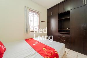 a bedroom with a bed and a tv and cabinets at RedLiving Apartemen Mediterania Palace - Meditrans Property Tower B in Jakarta