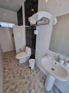 La salle de bains est pourvue d'un lavabo, de toilettes et d'un miroir. dans l'établissement MonMin Farmstay, à Ban Mae Cho
