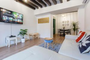 sala de estar con sofá blanco y TV en TACITA Family Home by Cadiz4Rentals, en Cádiz