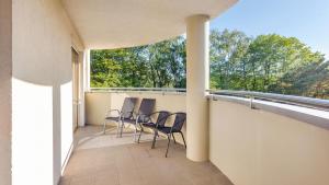 a balcony with chairs and a view of trees at Apartamenty Sun & Snow Wczasowa Apartamenty Południowe in Ustka