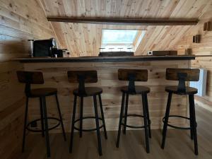 three bar stools sitting at a bar in a cabin at Le Chalet in Verdun-sur-Meuse