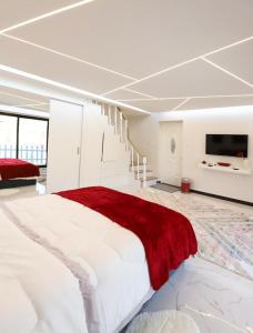 Red_Hut_Resort في Sharīyah: غرفة نوم كبيرة مع سرير كبير وتلفزيون