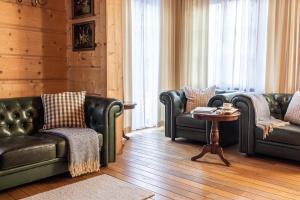 - un salon avec des canapés en cuir et une table dans l'établissement Dom Crocus, à Zakopane