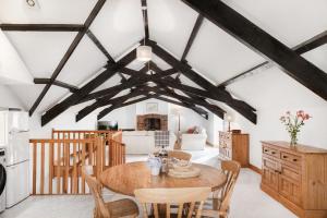 a kitchen and dining room with a wooden table and chairs at Downe Cottages in Hartland