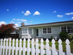 a white picket fence in front of a house at Cheerful 4 Bedroom Holiday Home (Sleeps 7) in Rotorua