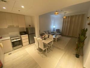 uma cozinha e uma sala de estar com mesa e cadeiras em Home-like modern 1 bedroom apartment SeaWorld view em Abu Dhabi