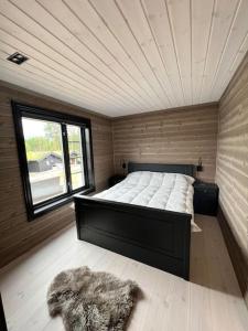 um quarto com uma cama num quarto com uma janela em Ny eksklusiv hytte i Vrådal med perfekt beliggenhet- Alpin og ski em Vradal