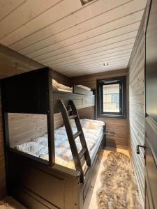 ヴラダルにあるNy eksklusiv hytte i Vrådal med perfekt beliggenhet- Alpin og skiの小さな家の中にある二段ベッド2台付きの部屋です。
